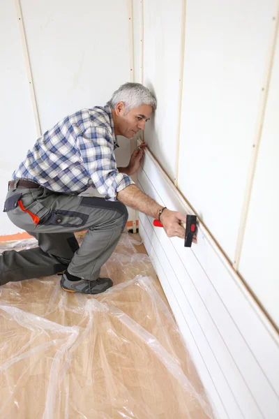 Man putting up interior wood cladding — Stock Photo, Image