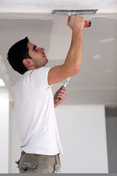 Человек оштукатуривает потолок — стоковое фото