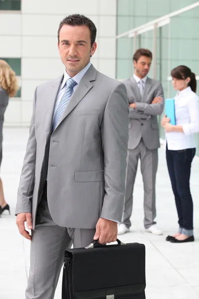 Человек с портфелем возле офисного здания — стоковое фото