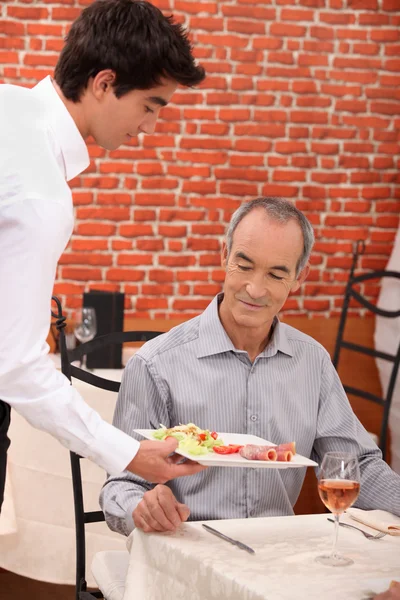 Servitör som serverar mat — Stockfoto