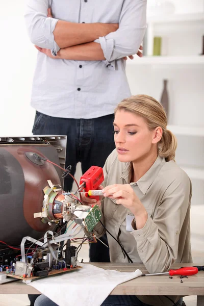Woman repairing television — Stock Photo, Image