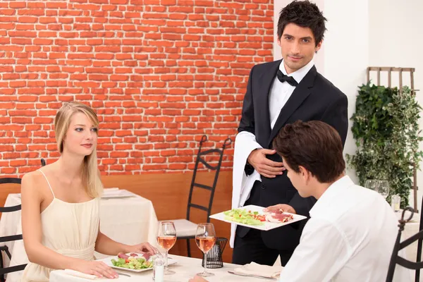 Kelner obsługujących młoda para — Zdjęcie stockowe