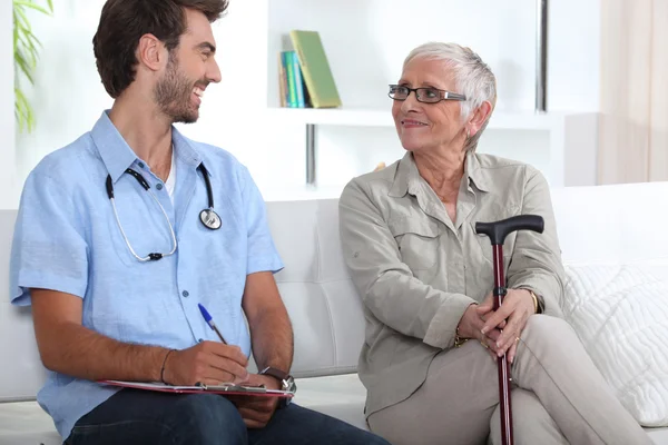 Senior woman talking to a young medic — Stok fotoğraf