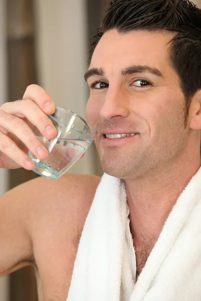 Uomo nudo che beve un bicchiere d'acqua — Foto Stock