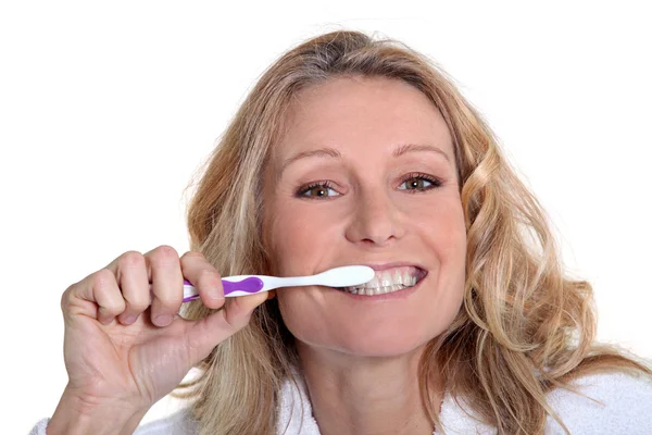 45 anos de idade mulher loira está escovando os dentes — Fotografia de Stock