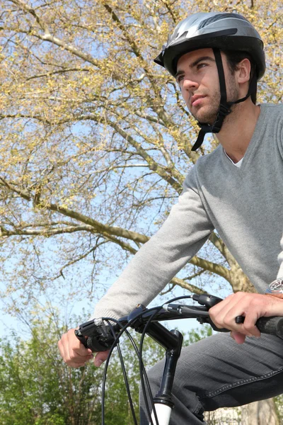 Hombre con casco en su bicicleta — Foto de Stock