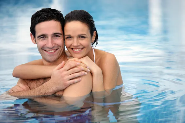 Casal feliz abraçando em uma piscina — Fotografia de Stock