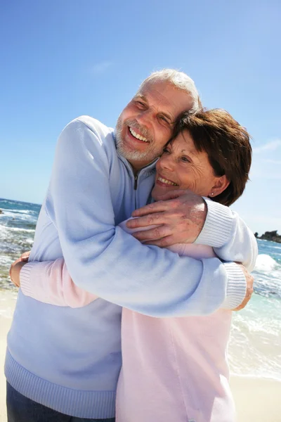 Älteres Paar umarmt sich am Strand — Stockfoto