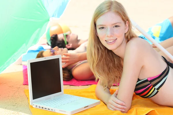 Portret van een vrouw op het strand met laptop — Stockfoto