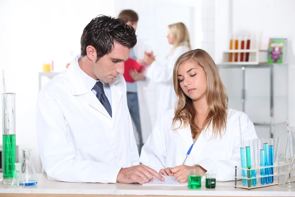 Science teacher helping student in laboratory — Stock Photo, Image