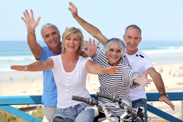 Happy foursome gone for a ride by oceanfront — Stock Photo, Image