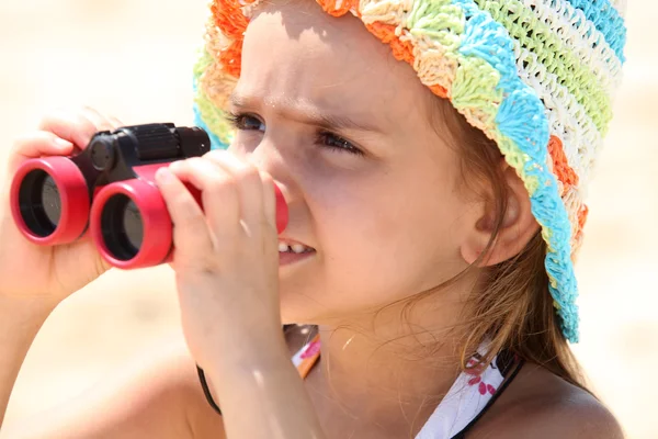 쌍안경으로 바닷가에 어린 소녀 스톡 사진