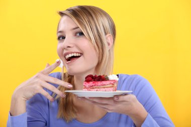 Young woman eating a piece of cake clipart