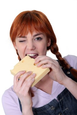 Woman biting into block of cheese clipart