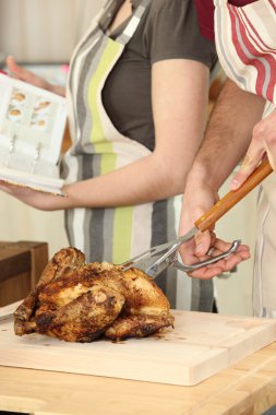 Man cutting chicken on a cutting board clipart