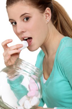 Woman eating marshmallows from jar clipart