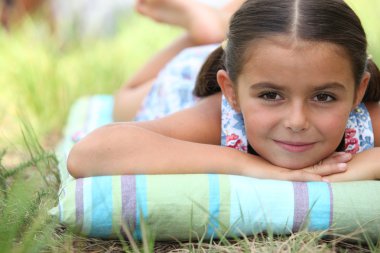 Young girl lying on the grass clipart