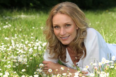 Woman lying in a field of daisies clipart