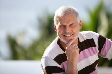 Elderly man sitting in garden clipart