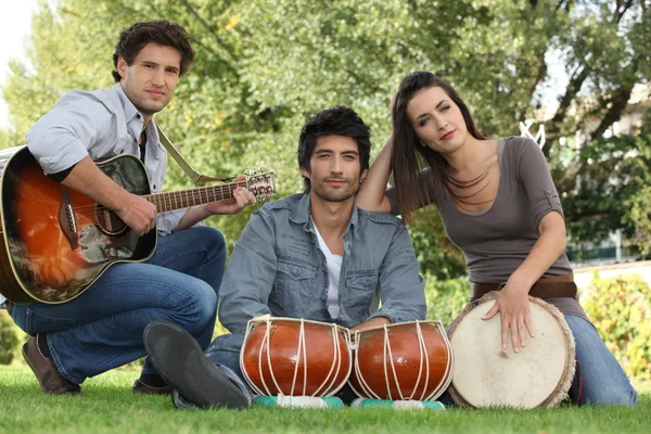 Three musicians in a park — Stock Photo, Image