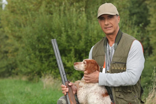 Jäger duckt sich mit Hund — Stockfoto