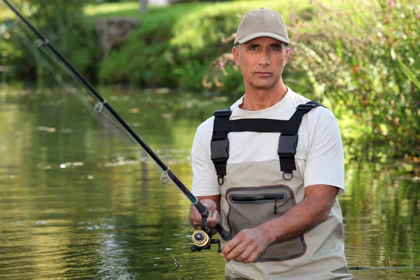 Mature man fishing in a river — Stock Photo, Image