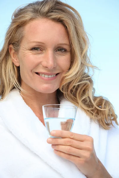 Kvinna dricka ett glas vatten i morgonrock — Stockfoto