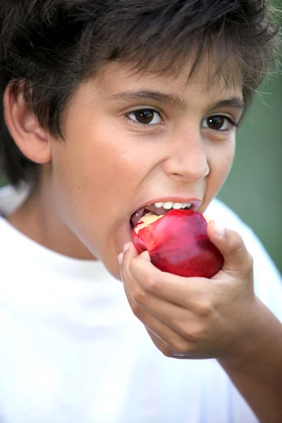 Jongen eet een appel — Stockfoto