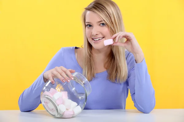 Sorrindo menina comendo marshmallows — Fotografia de Stock