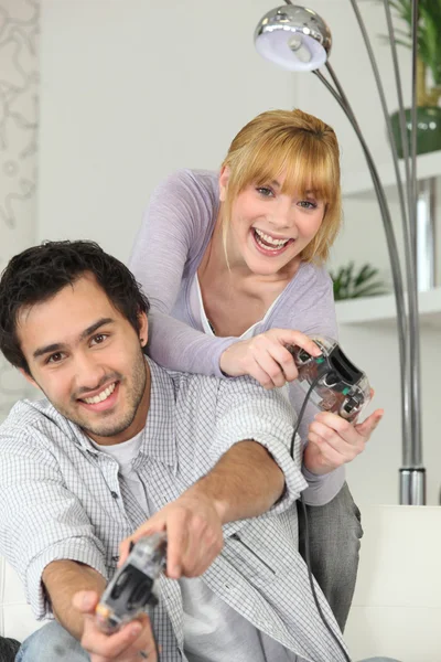 Mujer joven y hombre joven jugando videojuegos — Foto de Stock