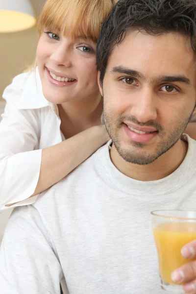 Couple with a glass of orange juice — Stock Photo, Image
