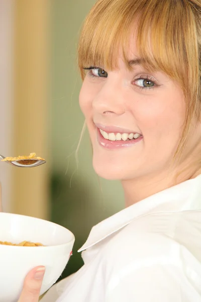 ボウルにコーンフレークを食べる若い女性 — ストック写真