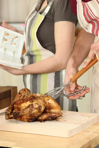Man skär kycklingen på en skärbräda — Stockfoto