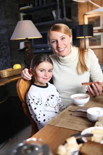 Mother and daughter eating breakfast together — Stock Photo, Image