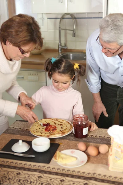 Familie bereitet Pfannkuchen zu — Stockfoto