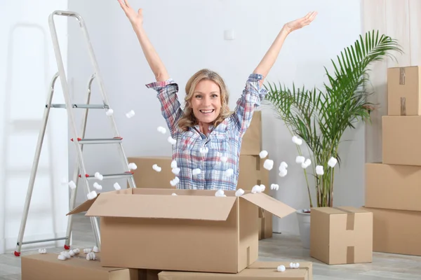 Mujer en nuevo hogar rodeada de cajas —  Fotos de Stock