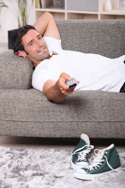 남자 집 보는 텔레비전에서 소파에 누워 — 스톡 사진