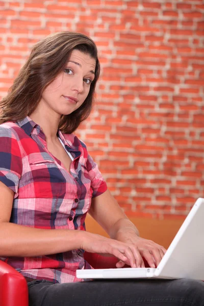 Mulher usando laptop com expressão de espanto — Fotografia de Stock
