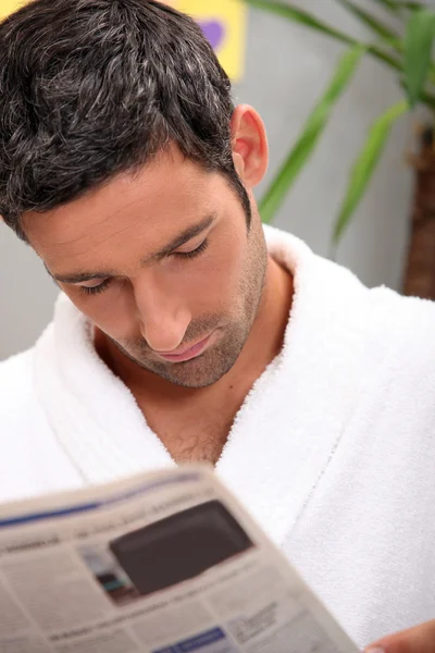 Mann liest Morgenzeitung in Küche — Stockfoto