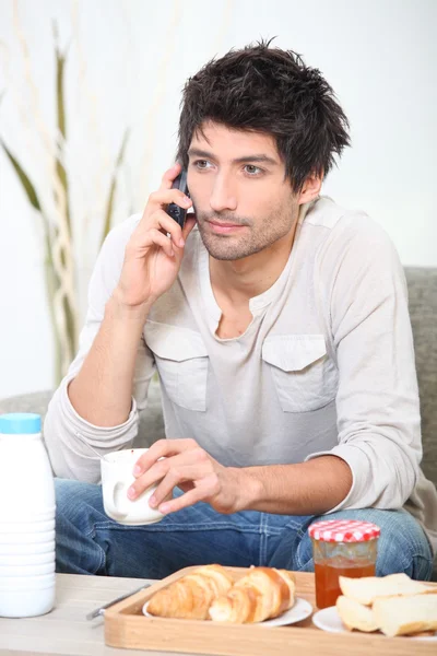 Man making a phone call over breakfast — Stock Photo, Image