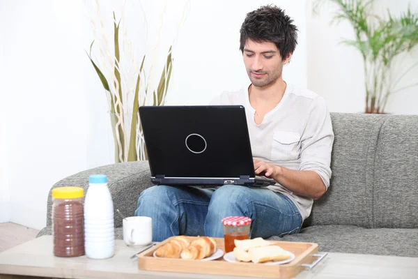 Homem olhando para seu laptop antes do café da manhã — Fotografia de Stock