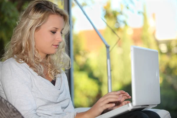 Junge Frau benutzt Laptop im Haus — Stockfoto