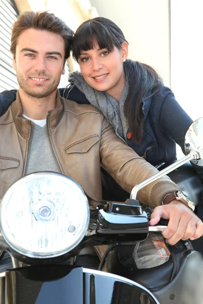 Attractive couple riding scooter — Stock Photo, Image
