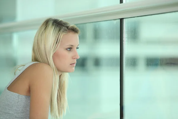 Rubia mujer adolescente sentado mirando por la ventana — Foto de Stock