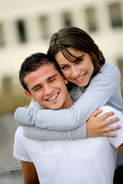 Couple hugging outside building — Stock Photo, Image