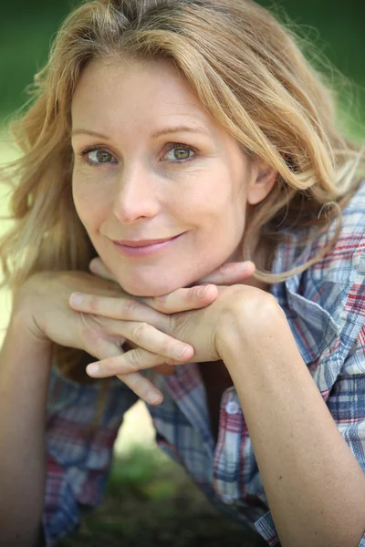 Retrato close-up de uma mulher sorridente em um ambiente ao ar livre — Fotografia de Stock
