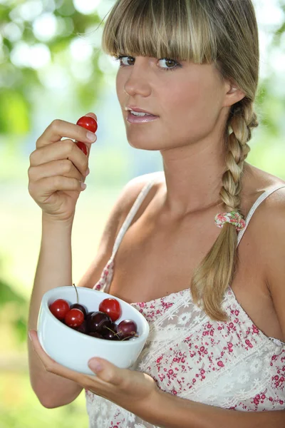 Kvinna äta körsbär — Stockfoto