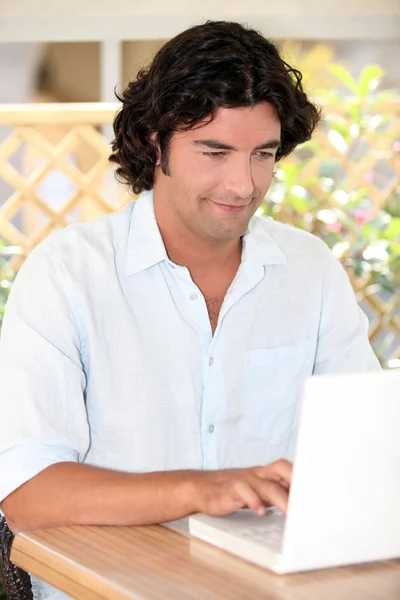 Casualmente vestido homem usando um computador portátil — Fotografia de Stock