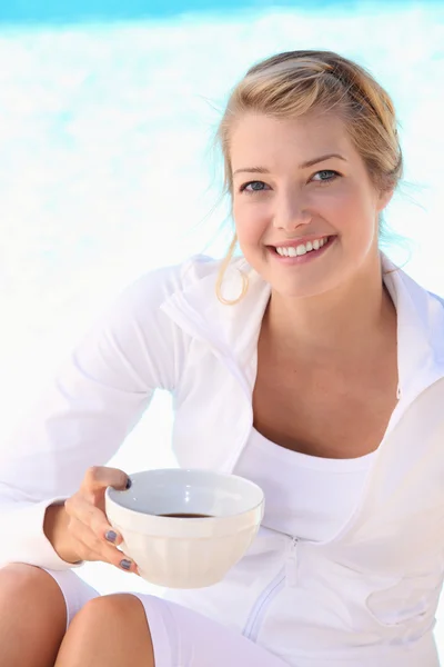 Mulher loira sentada e bebendo uma tigela de café — Fotografia de Stock