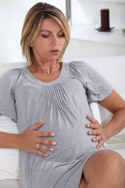 Mujer sosteniendo su estómago muy embarazada — Foto de Stock